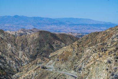 High angle view of rocky mountains against blue sky