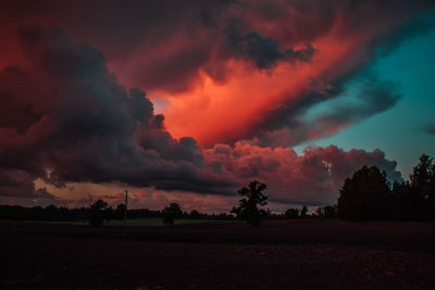 Scenic view of dramatic sky over land during sunset