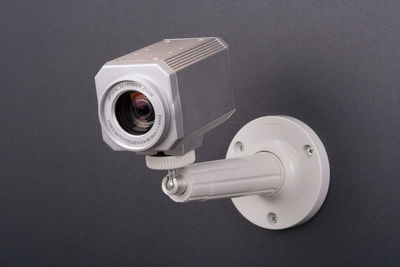 Close-up of security camera on black wall