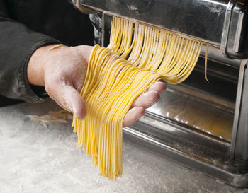 Cropped hand of man preparing pasta