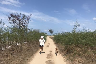 Full length of woman walking on field against sky