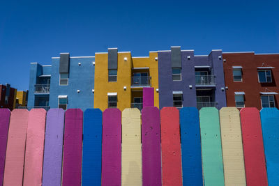 Low angle view of multi colored buildings against blue sky