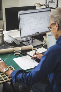 Craftsman examining while working on computer at office