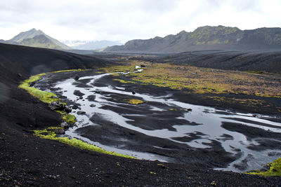 Scenic view of river amidst mountains against sky