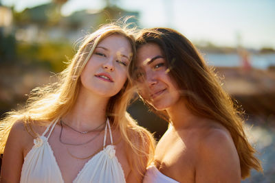 Portrait of beautiful young female friends with long brown hair