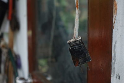 Close-up of old rusty metal hanging against wall