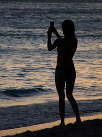 Two people standing on beach