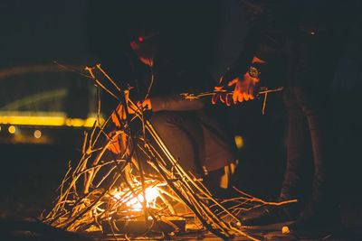 Friends by campfire on field during night