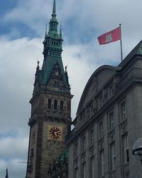 Low angle view of clock tower against cloudy sky