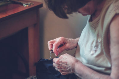 Midsection of woman holding while sitting at home