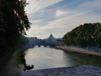 Arch bridge over river against sky during sunset