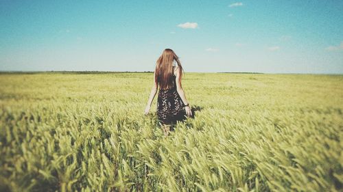 Woman standing on field against sky