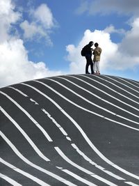 Rear view of man and woman standing against sky