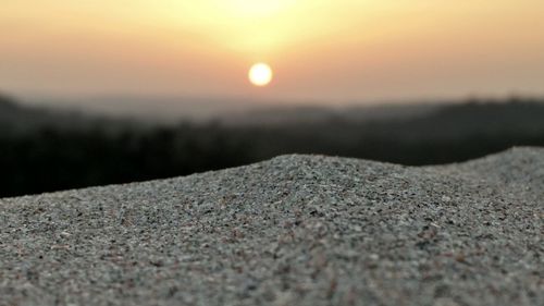 Close-up of landscape against sky during sunset