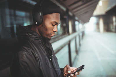 Midsection of man using mobile phone in bus