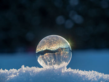 Close-up of bubbles on crystal ball against sky