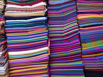 Full frame shot of stacked colorful fabrics for sale at store