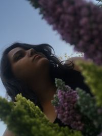 Portrait of woman against pink flowering plants