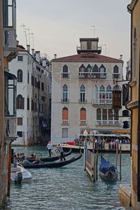 Boats in canal against buildings in city