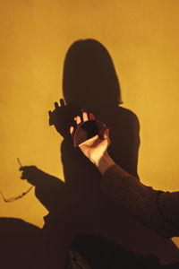 Portrait of silhouette man holding orange wall
