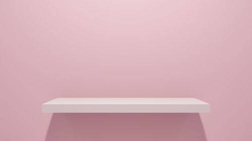 Low angle view of empty paper against pink background