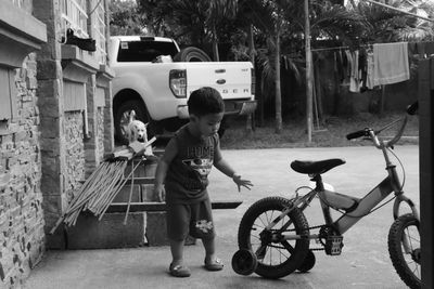 Full length of boy standing on bicycle