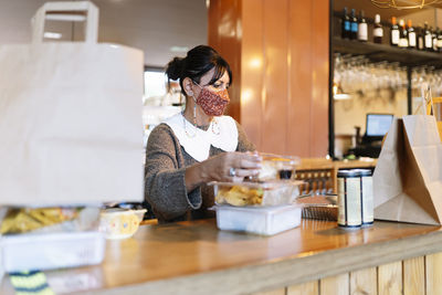 Midsection of woman holding smart phone at restaurant