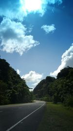 Empty road with trees in background