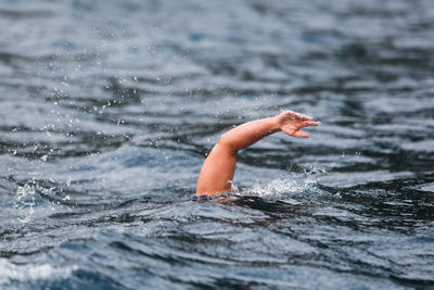 Low section of man swimming in sea