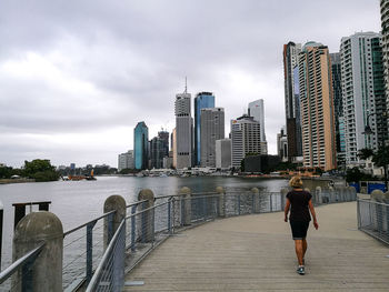 Rear view of woman walking on bridge