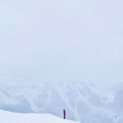 Person on snow covered mountain against sky