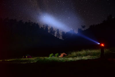 Scenic view of illuminated field against sky at night