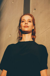 Low angle view of woman standing against wall