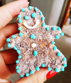 Close-up of hand holding gingerbread cookie