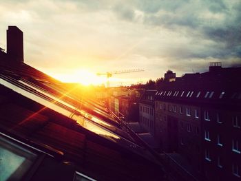 Sun shining through clouds over city
