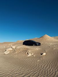 Scenic view of desert against clear blue sky