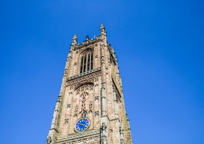 Low angle view of clock tower against a striking blue sky