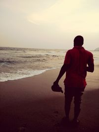 Rear view of man walking on beach