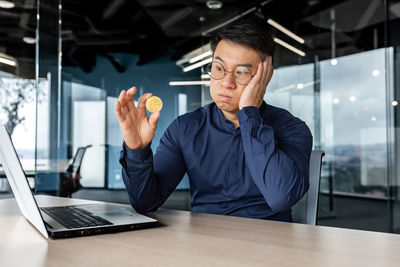 Businesswoman using mobile phone while sitting on table