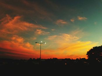 Silhouette of trees against cloudy sky during sunset