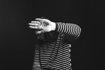 Rear view of man standing against black background