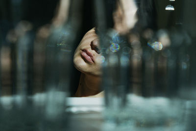 Close-up of young woman looking through window