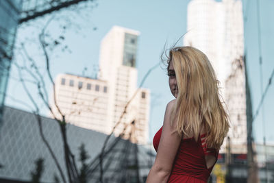 Portrait of woman standing against buildings