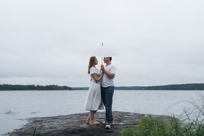 Rear view of woman standing against lake