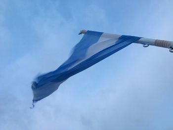 Low angle view of flag against blue sky