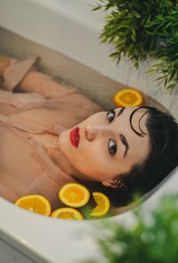 High angle portrait of woman lying in bathtub at home