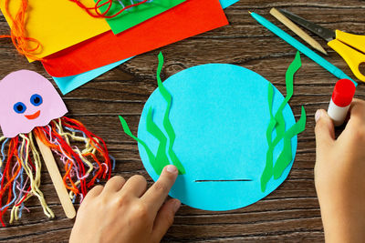 High angle view of hand holding colored table