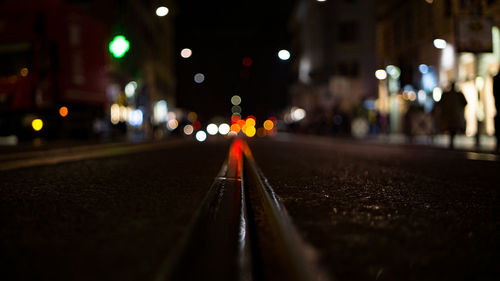 Surface level of railroad tracks on city street at night
