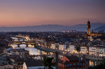 High angle view of city lit up at sunset