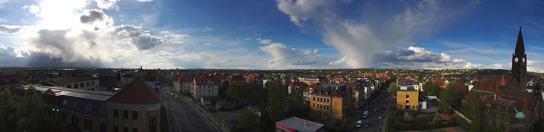 Panoramic view of cityscape against cloudy sky